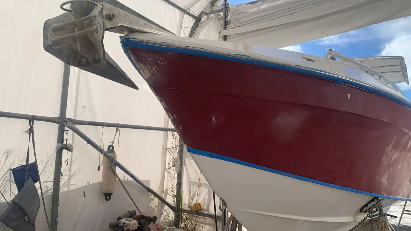 Fresh burgundy bootstripe and gloss white hull on a sportfish bow by SXM Refinishing in St. Maarten