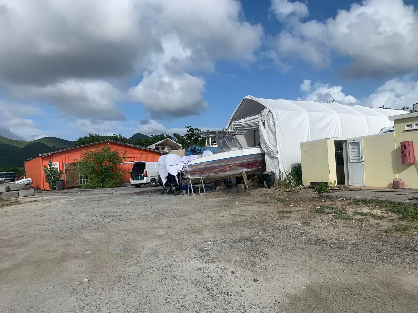 Covered spray tent with a masked centre console at our St. Maarten yard — SXM Refinishing