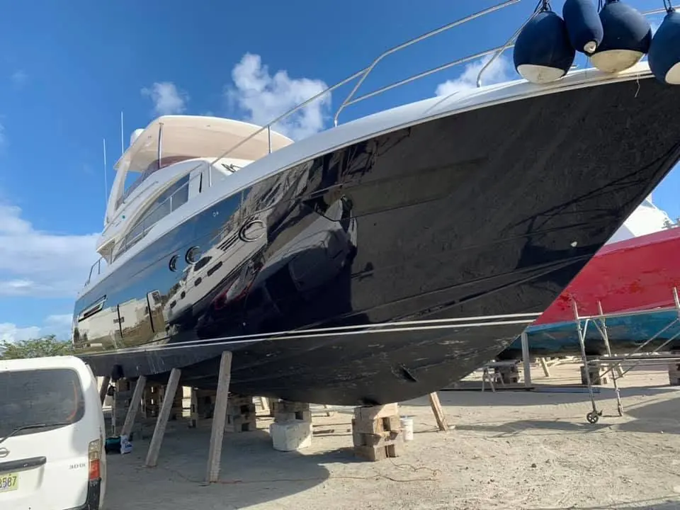 Freshly varnished teak deck with polished stainless steel rails by SXM Refinishing in St. Maarten