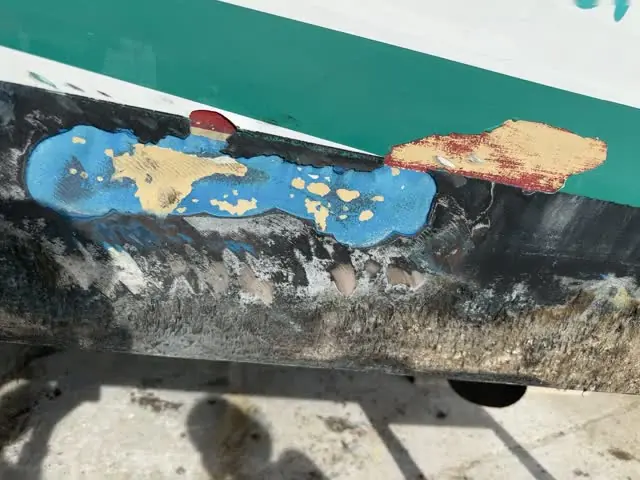 Osmosis and gelcoat damage exposed on a hull before repair by SXM Refinishing in St. Maarten